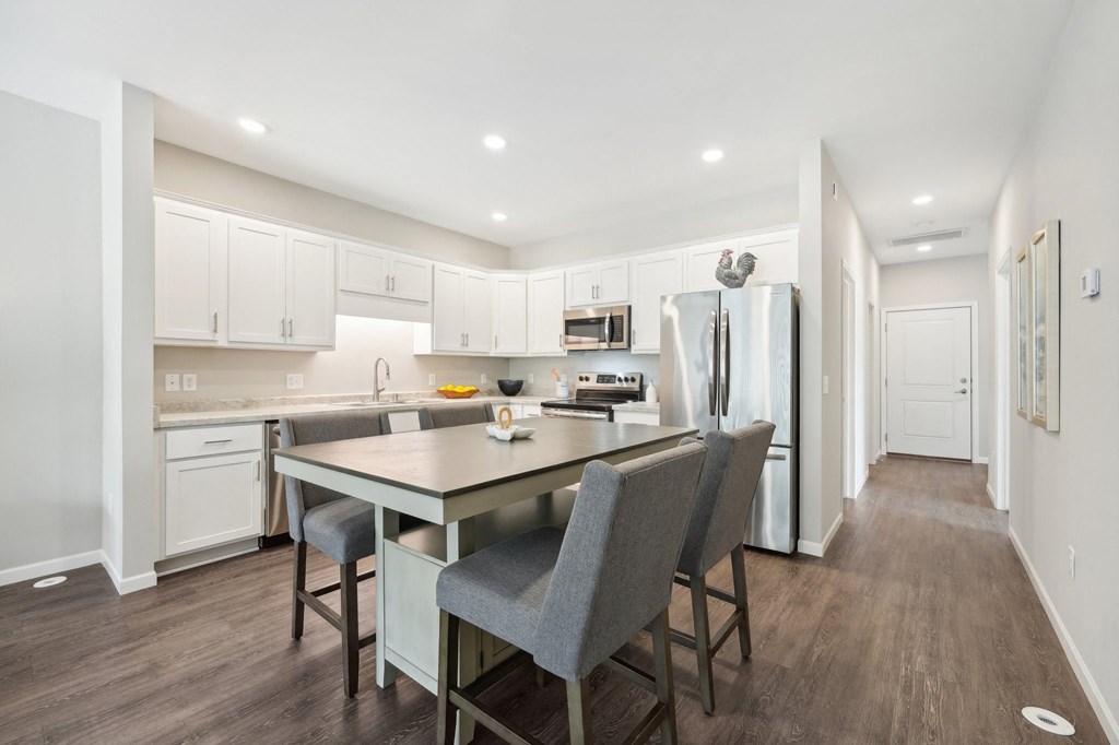 Kitchen a kitchen with white cabinets and a large island with chairs