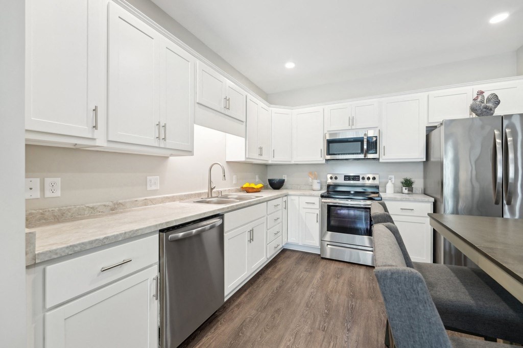 a kitchen with white cabinets and stainless steel appliances