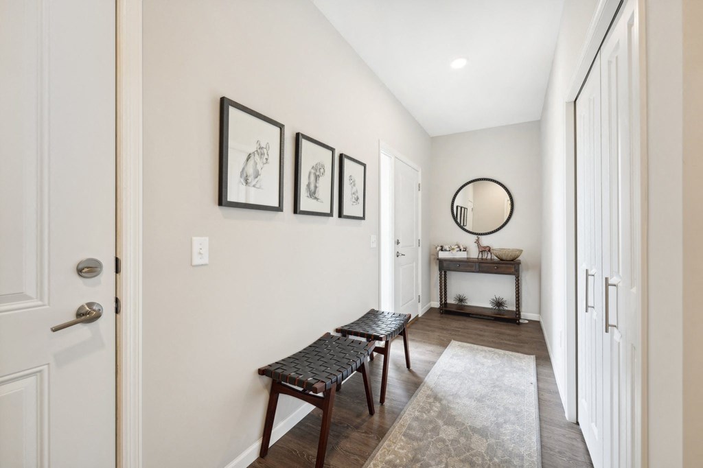 Entry hallway with two benches and a mirror and a door