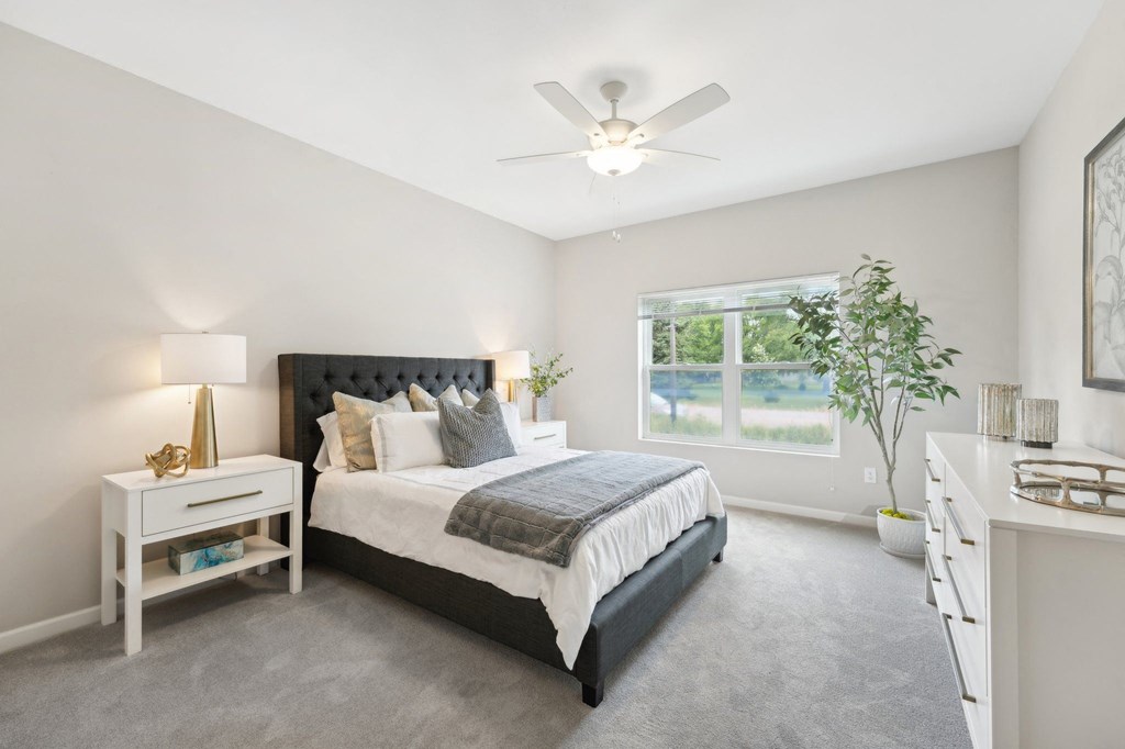spacious bedroom with a bed  and a big window