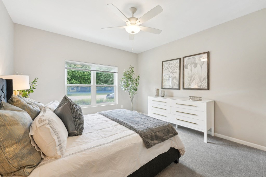 a bedroom with a bed and a ceiling fan