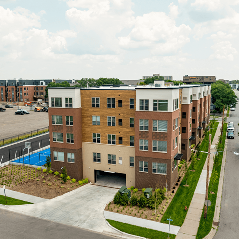 A modern apartment building with a pool in the backyard.
