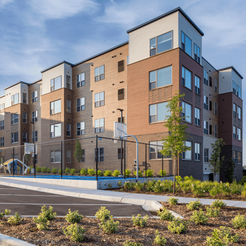 A modern apartment building with a playground in front.