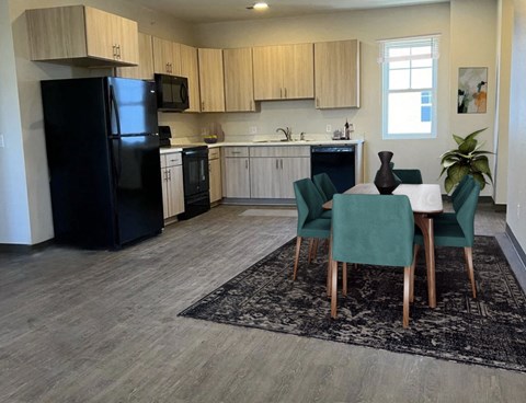 a kitchen with a table and chairs and a black refrigerator