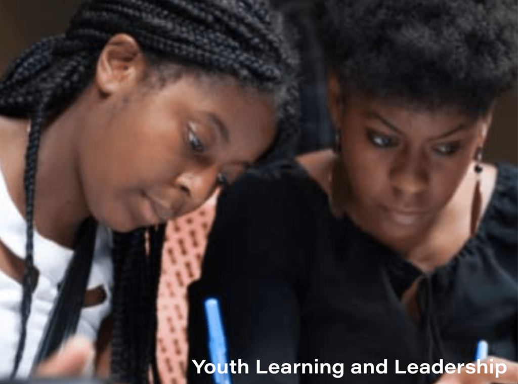 Two young women studying with a focus on youth learning and leadership.