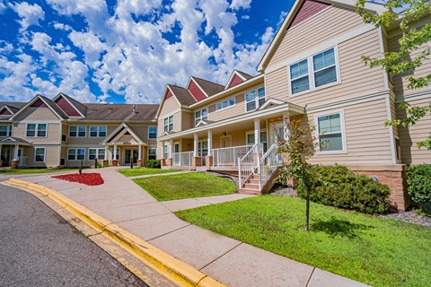 A row of houses with a red flower bed in front of the first house.