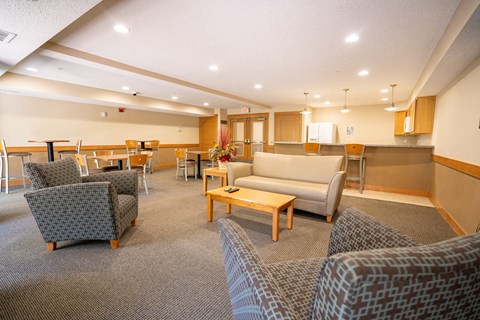 A room with a grey carpet and a wooden table.