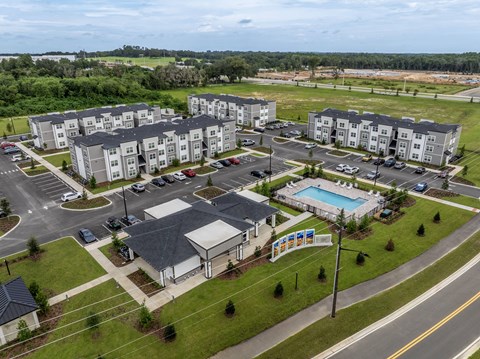 A large apartment complex with a swimming pool and a playground.