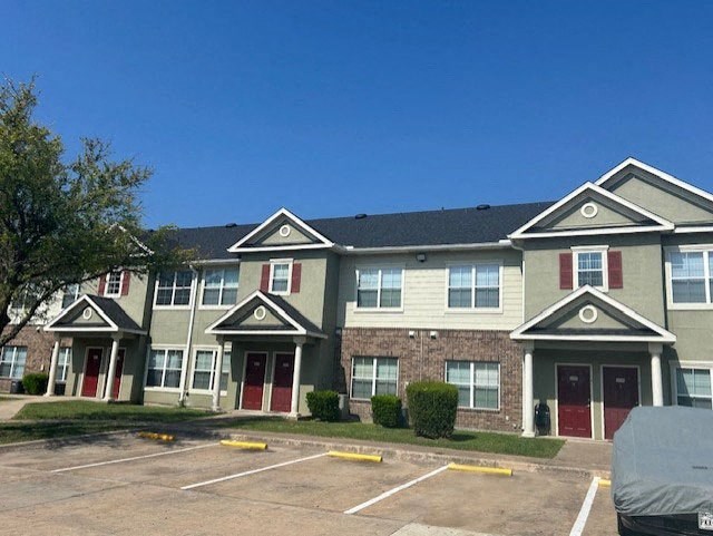 a large apartment building with red doors and a parking lot