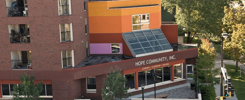 A building with a solar panel on the roof and the words "Hope Community, Inc." on the front.