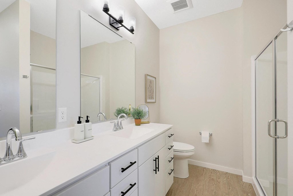A bathroom with a white counter top and a white toilet.