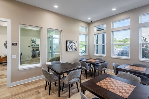 A dining room with a chess board on the table.