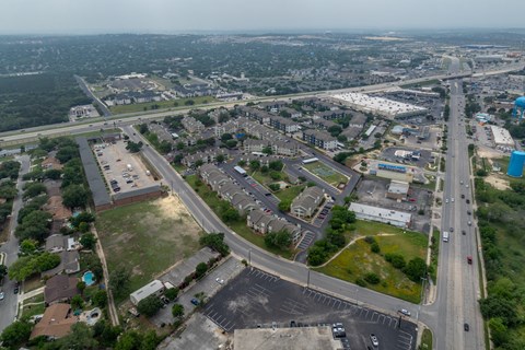 an aerial view of a city with an intersection with cars and buildings
