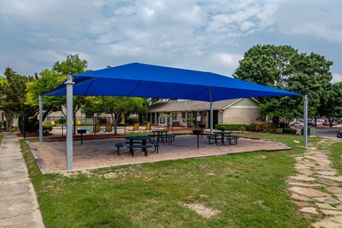 a blue pavilion with picnic tables under it      in front