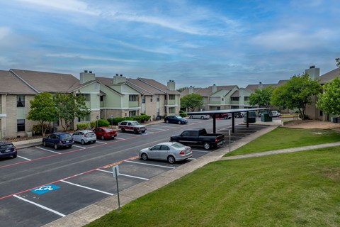 a parking lot filled with cars in front of houses