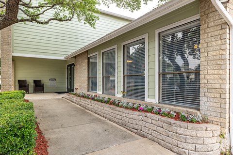 a walkway in front of a building with windows and a sidewalk