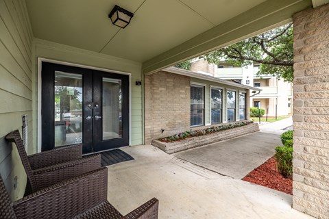 front porch of a house with two chairs and a patio