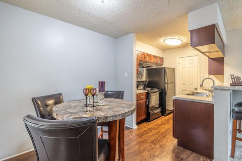 A kitchen with a table and chairs in the foreground.