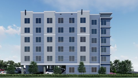 A modern multi-story building with a parking lot in front.