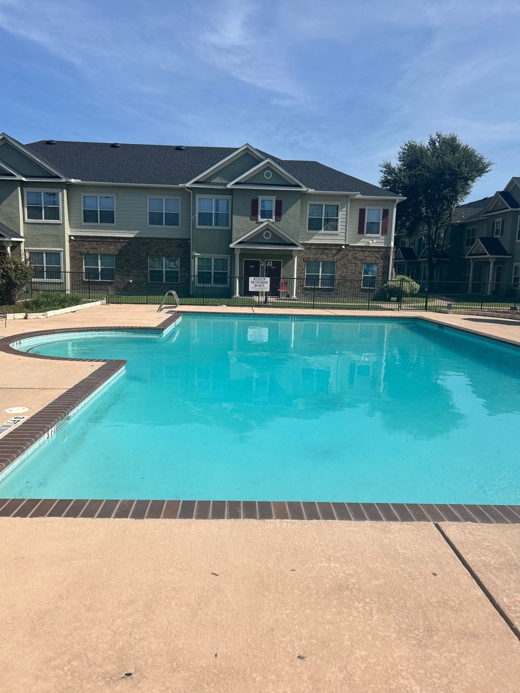 a large swimming pool with an apartment building in the background