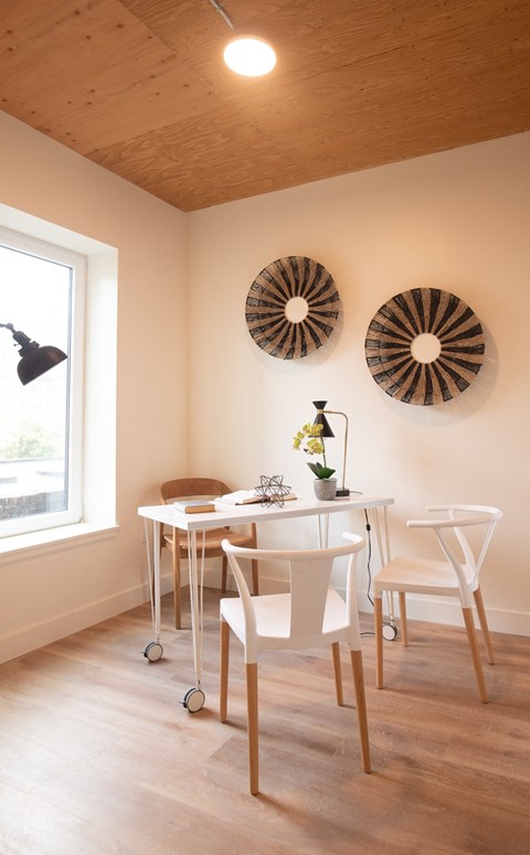 a dining room with a white table and chairs and a window
