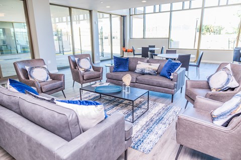 A living room with grey couches and blue pillows.