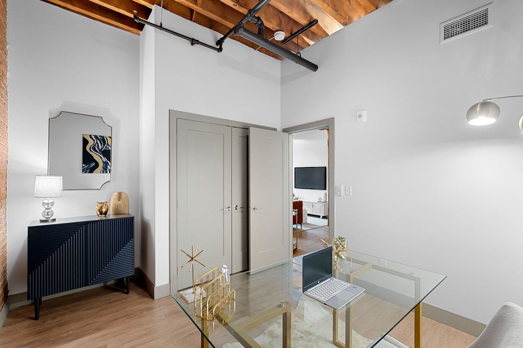 a living room with a glass desk and a glass table