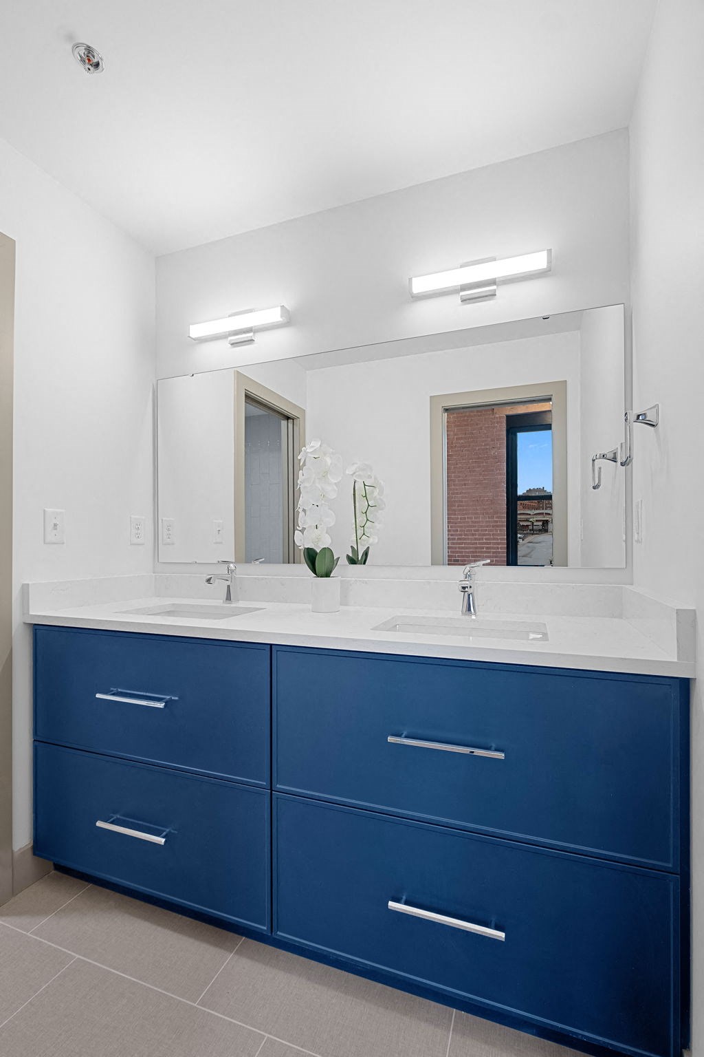 a blue and white bathroom with a sink and a mirror