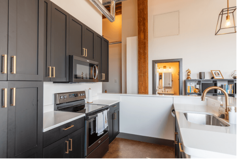 a kitchen with black and white cabinets and a sink