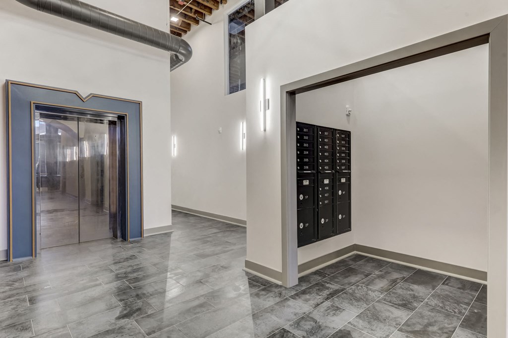a large room with a door to a mail room and a locker