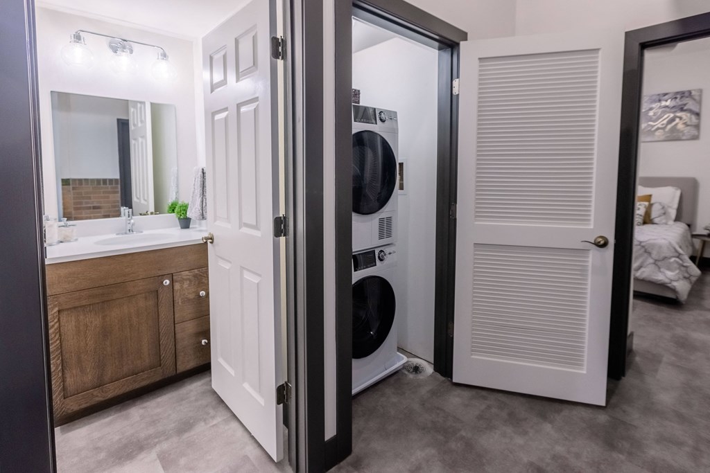a bathroom with a washer and dryer in it and a door to a