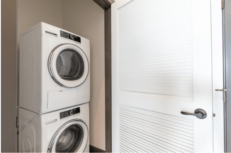 a small laundry room with a washer and dryer next to a door