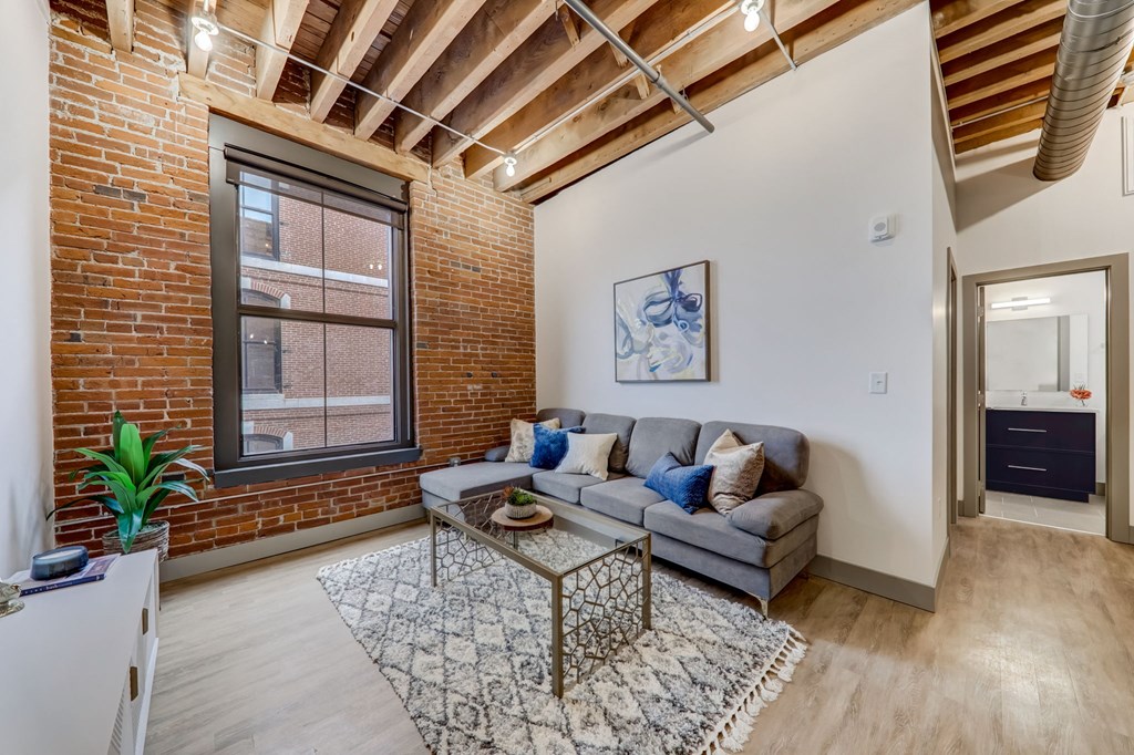 a living room with a couch and a coffee table in front of a window