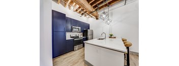 A kitchen with a white countertop and blue cabinets.