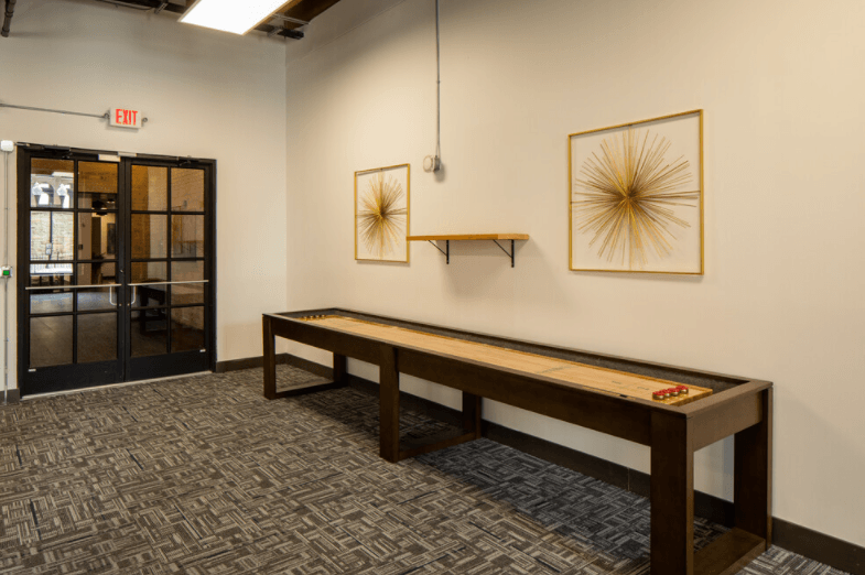 a room with a ping pong table and paintings on the wall