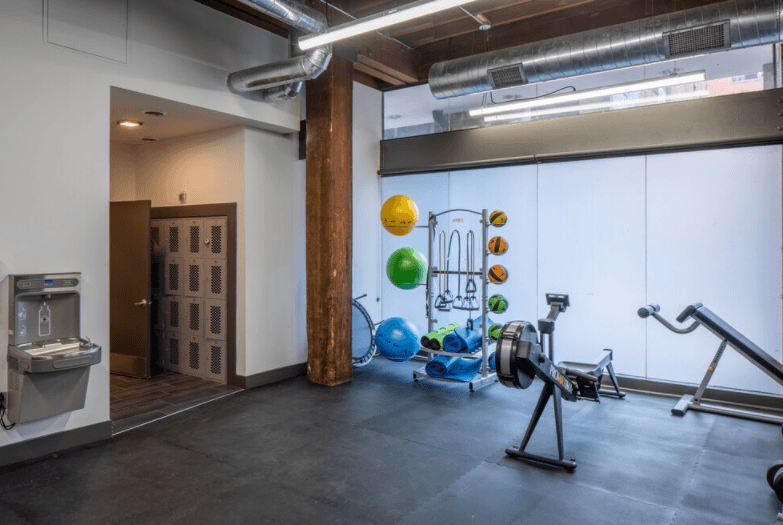 a workout room with weights and other exercise equipment in a loft