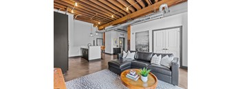 A living room with a grey couch and a coffee table in the middle.