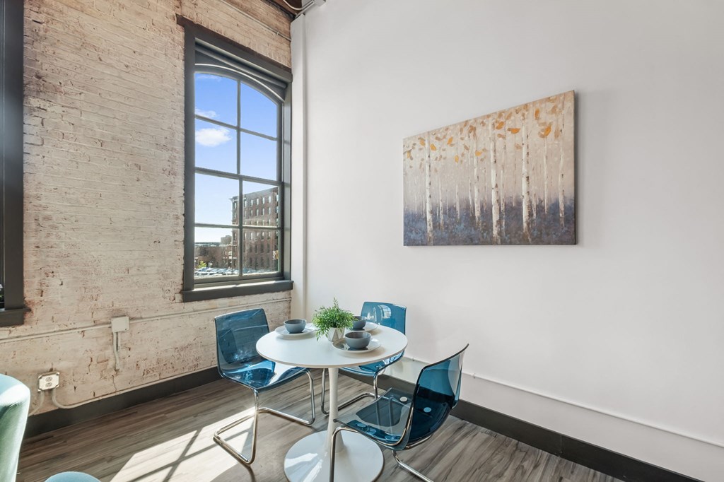 a dining area with a table and chairs and a large window