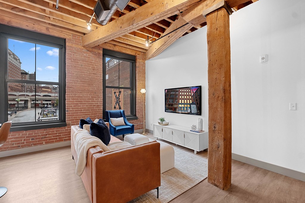 a living room with a brick wall and a large window