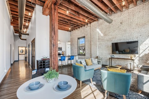a living room with a table and chairs and a tv