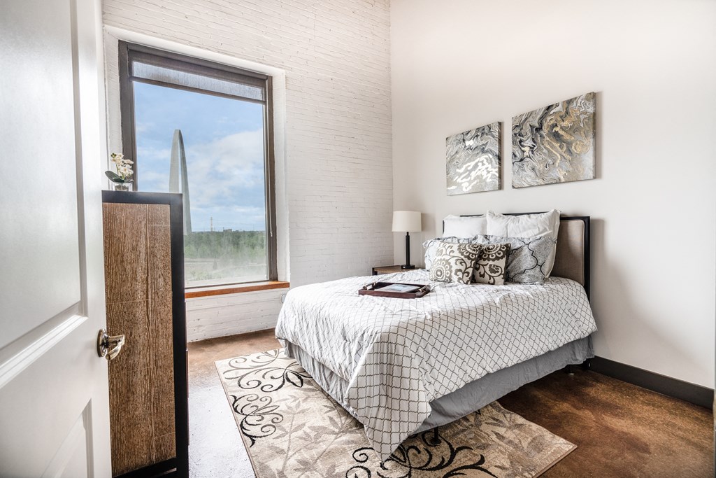 a bedroom with a bed and a large window