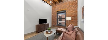 A living room with a brown leather couch and a flat screen TV.