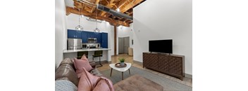 A living room with a brown leather couch and a brown cabinet.