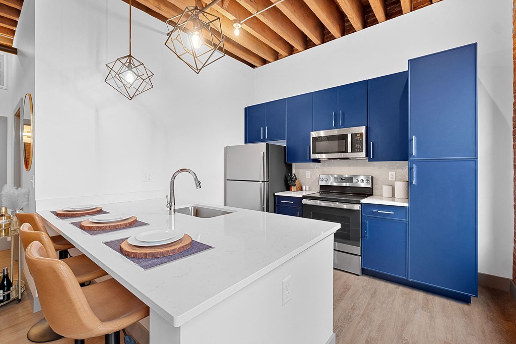 a kitchen with blue cabinets and a white counter top