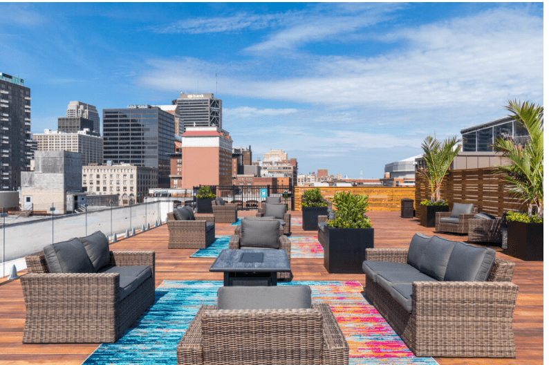 a roof top patio with furniture and a view of the city