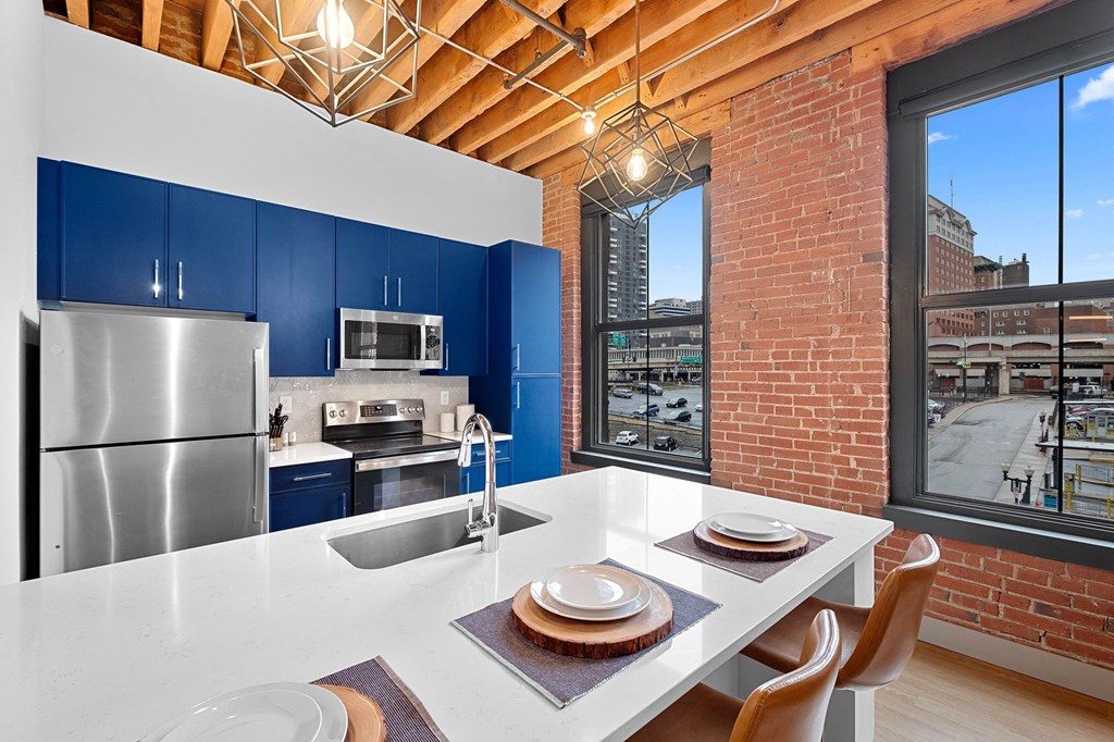a kitchen with a white counter top and a stainless steel refrigerator