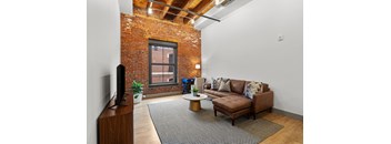 A living room with a brown couch and a television.