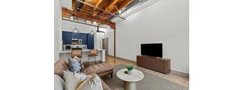 A living room with a brown leather couch and a white coffee table.
