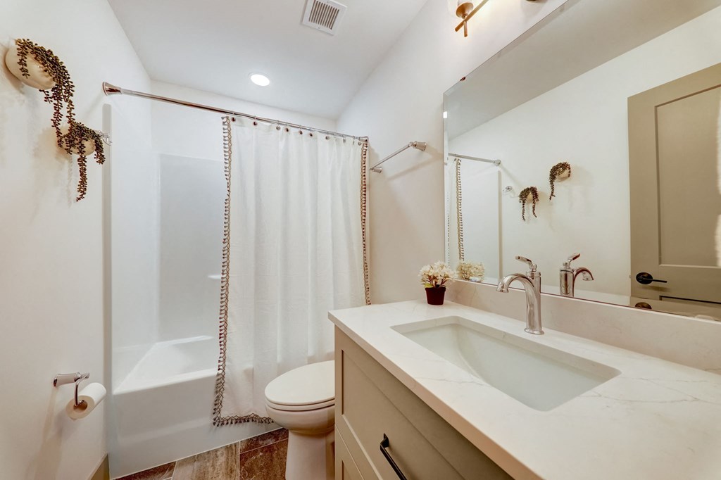 a bathroom with a shower and a sink and a toilet at Greeley Lofts, St. Louis, MO