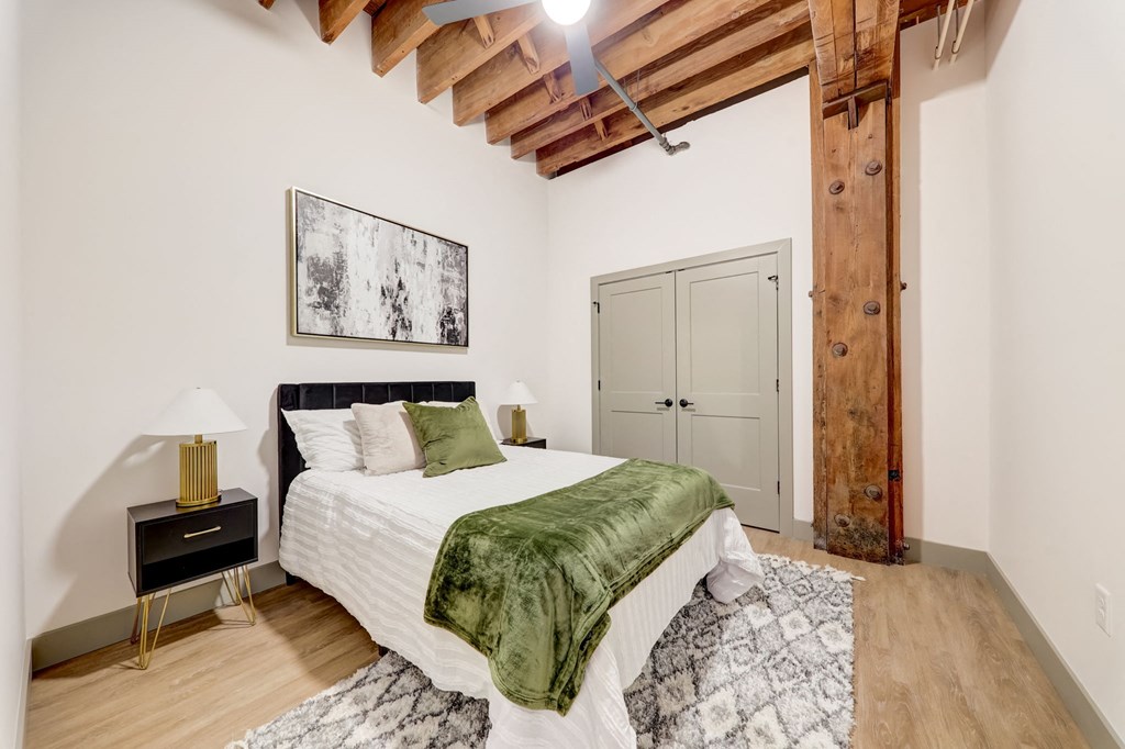 a bedroom with a bed and a green blanket at Greeley Lofts, Missouri